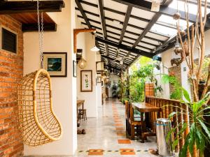 a corridor of a restaurant with a hanging rattan chair at Palm Mansion Boutique Suites in George Town