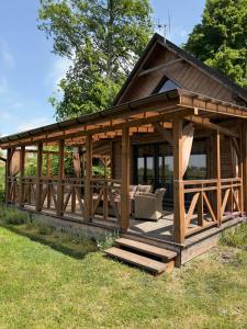 a large wooden gazebo in the grass at Domek z jacuzzi Wypoczynek Pod Lipami in Wólka