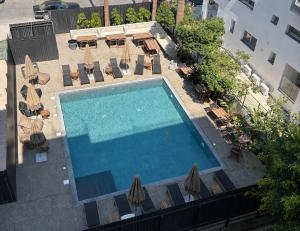 an overhead view of a swimming pool with chairs and umbrellas at Sunflower Hotel Apartments in Larnaca
