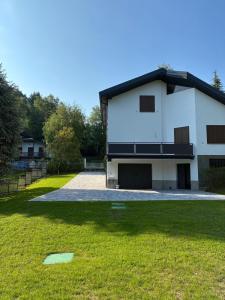 a white house with a black roof and a yard at Casa RIGPA in Bellagio