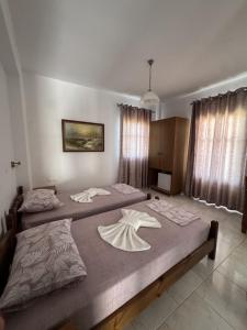 two beds sitting in a bedroom with at Nikos Apartments in Lefkos Karpathou