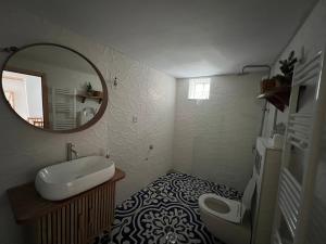 a bathroom with a sink and a mirror and a toilet at Nevoliani stone house in Florina