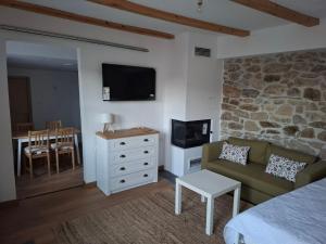 a bedroom with a couch and a tv and a table at Nevoliani stone house in Florina +4 photos