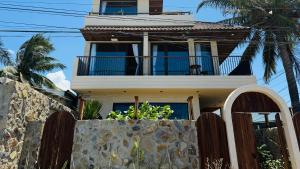 a house with a balcony and a stone wall at Phuongvilla Đông Hải in Thôn Ðông Giang +1 photo