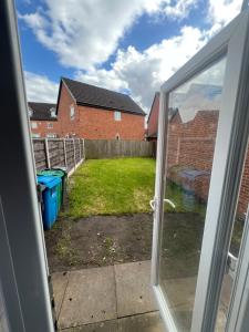 a view of a yard from a sliding glass door at Favour homes in Manchester +21 photos