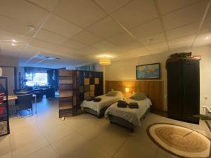 a bedroom with two beds and a desk in it at Kom tot rust in The Forest in Putte