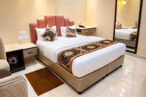 a bedroom with a large bed with a large mirror at Hotel Anant Inn in Varanasi