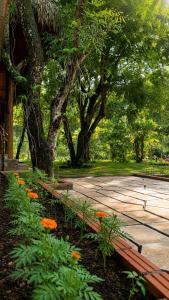 a park with a bench and trees and flowers at Mai Chau Ecohouse in Mai Châu
