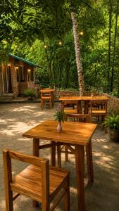 a group of wooden tables and benches in a park at Mai Chau Ecohouse in Mai Châu