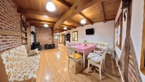 a dining room with a table and chairs and a brick wall at Sekin Vinograd in Voloder