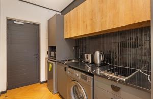 a kitchen with a washing machine and a washer at Nine Palms Studio Retreat Century City in Cape Town