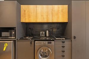 a kitchen with a washing machine and a sink at Nine Palms Studio Retreat Century City in Cape Town