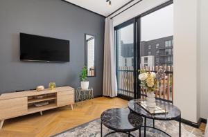 a living room with a tv and a large window at Nine Palms Studio Retreat Century City in Cape Town