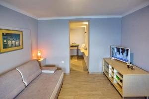 a living room with a couch and a television at Sunrise Suite in Kavála