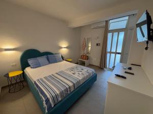 a bedroom with a bed and a television in it at Village La Canzone del Mare in Vieste