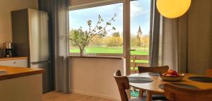 a kitchen and dining room with a table and a window at Cozy Home in Suuremõisa in Suuremõisa