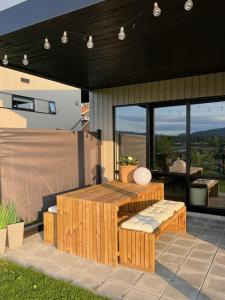 a patio with a wooden table and benches on a house at Oppheimhamna 10c in Bø