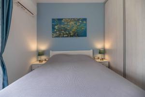 a bedroom with a white bed and two lamps at Antonis Studio in Archangelos