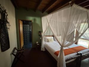 a bedroom with a canopy bed with a white mosquito net at Spacious Family Villa, close to Krugerpark entrance in Phalaborwa +31 photos