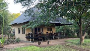 a building with tables and a thatched roof at Spacious Family Villa, close to Krugerpark entrance in Phalaborwa