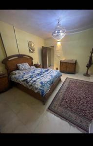 a bedroom with a bed and a rug and a chandelier at Pyramids Heritage suites in Ghaţāţī