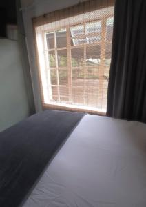a bedroom with a bed and a window at Bucklebury inn in Centurion