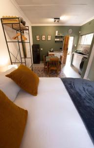 a large white bed in a room with a kitchen at Bucklebury inn in Centurion
