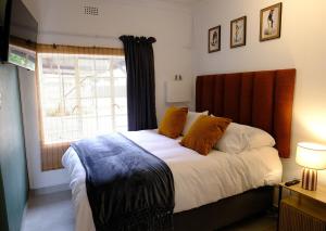 a bedroom with a large bed with a window at Bucklebury inn in Centurion