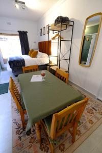 a room with a table and chairs and a bed at Bucklebury inn in Centurion