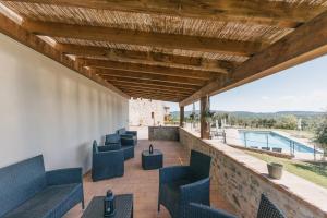 an outdoor patio with blue chairs and a swimming pool at Agriturismo Melariano in Castelnuovo Berardenga