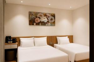 a room with two beds and a painting on the wall at Adora Hotel Khe Sanh in Khe Sanh +25 photos