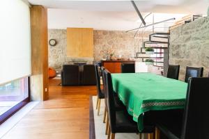 a dining room with a green table and chairs at Holly Country House in Paredes de Coura