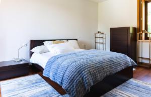 a bedroom with a bed with a blue blanket at Holly Country House in Paredes de Coura