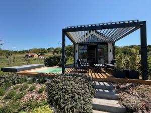 a wooden deck with a pergola and a pool at Lavendream in Kőröshegy
