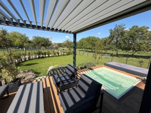 a patio with a swimming pool and a deck with chairs at Lavendream in Kőröshegy