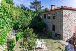an aerial view of a backyard with a stone house at Holly Country House in Paredes de Coura