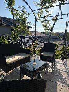 eine Terrasse mit zwei Stühlen, einem Tisch und einem Sofa in der Unterkunft Vila Aron in Tuzla