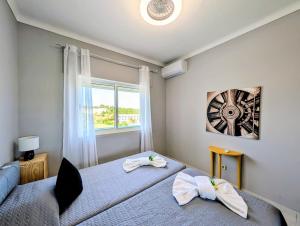 a bedroom with two beds and a window at 4º5 Edificio Mar - Casas & Papeis in Armação de Pêra