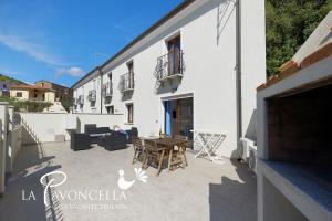 a patio of a house with a table and chairs at Case Vacanze La Pavoncella in Teulada