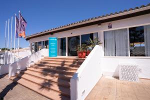 a building with white stairs and a blue sign on it at BLUESEA Marina Parc in Na Macaret