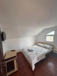 ein kleines Schlafzimmer mit einem Bett und einem Tisch in der Unterkunft Vila Aron in Tuzla