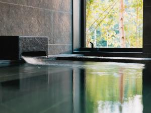 a window in a room with a reflection in the water at Locanda Furanora in Furano
