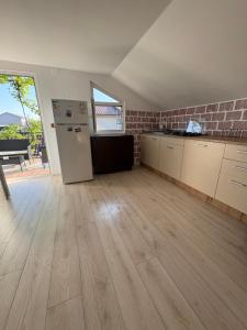 eine leere Küche mit einem Kühlschrank und einem Tisch in der Unterkunft Vila Aron in Tuzla