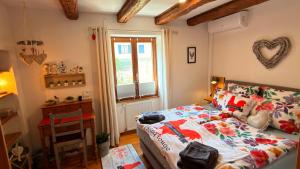 a bedroom with a bed and a table and a window at GITE LE COQ ROUGE in Eguisheim