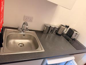 a kitchen counter with a sink and trash cans at Colne Hideaway in Colne