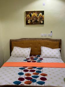 a bed with an orange and blue blanket on it at CHAMBREs SALON MEUBLÉ in Yamoussoukro