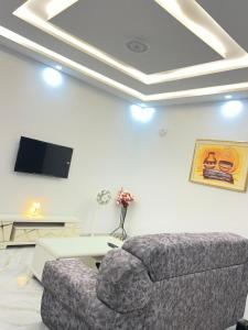 a living room with a couch and a tv at CHAMBREs SALON MEUBLÉ in Yamoussoukro