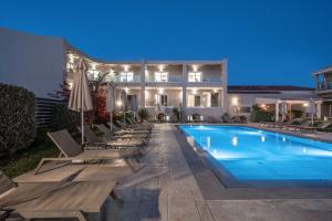 a swimming pool with lounge chairs and a hotel at Vice Hotel in Laganas