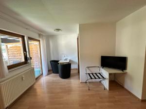 a room with a desk with a television and a chair at Hotel Gasthaus Stern in Nusplingen