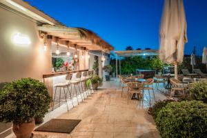 a patio with tables and chairs and a bar at Vice Hotel in Laganas